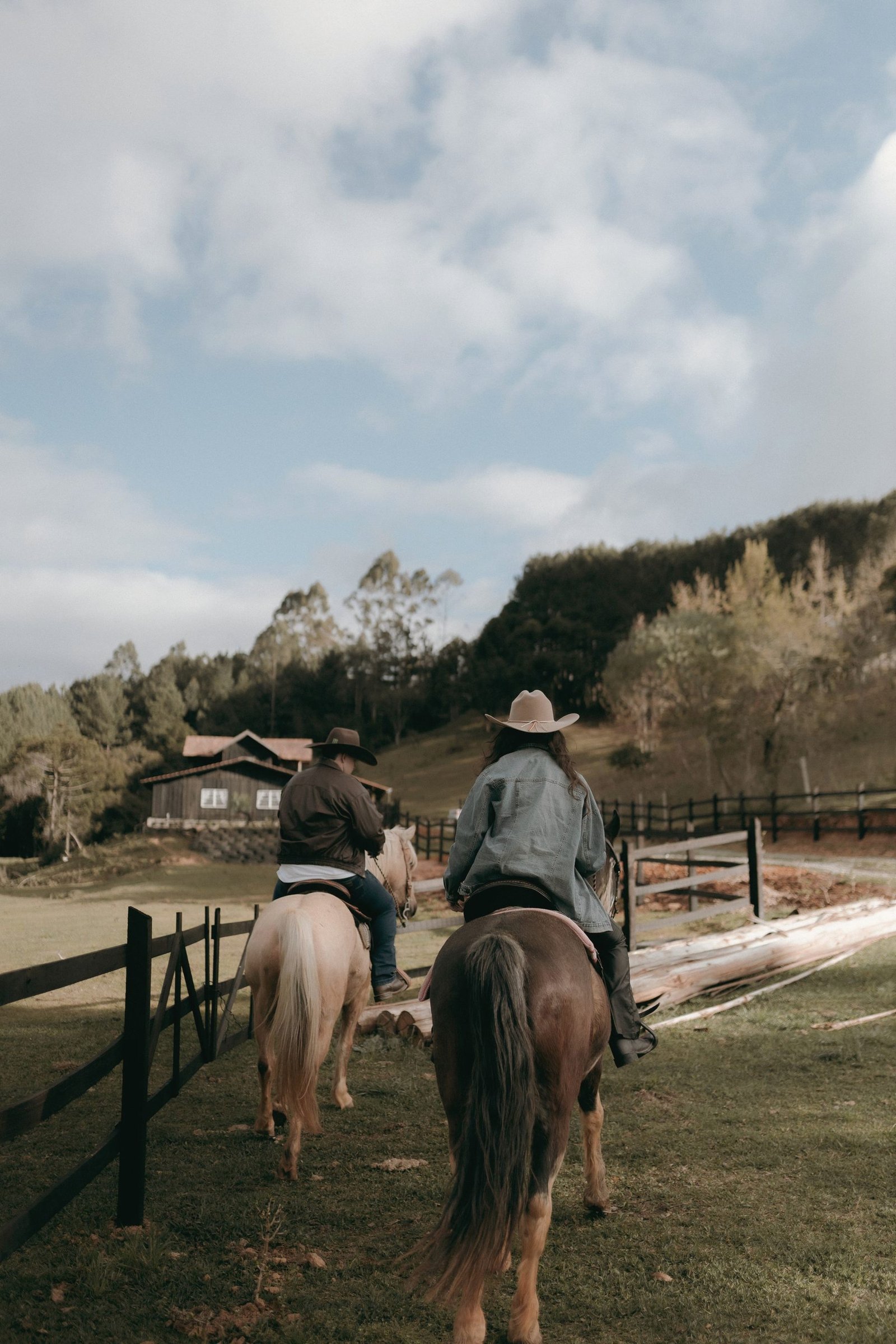 Riders on horseback crossing open ground under a wide sky.